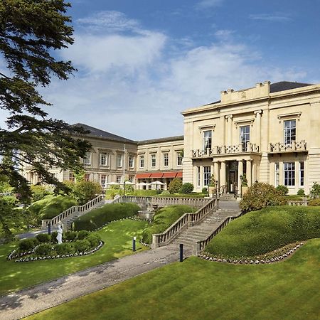 Macdonald Bath Spa Hotel Εξωτερικό φωτογραφία The photo shows a grand building, likely a hotel or estate, surrounded by well-manicured gardens and lawns. The architecture appears elegant, with multiple stories and large windows. There are steps leading up to the entrance, and the setting include