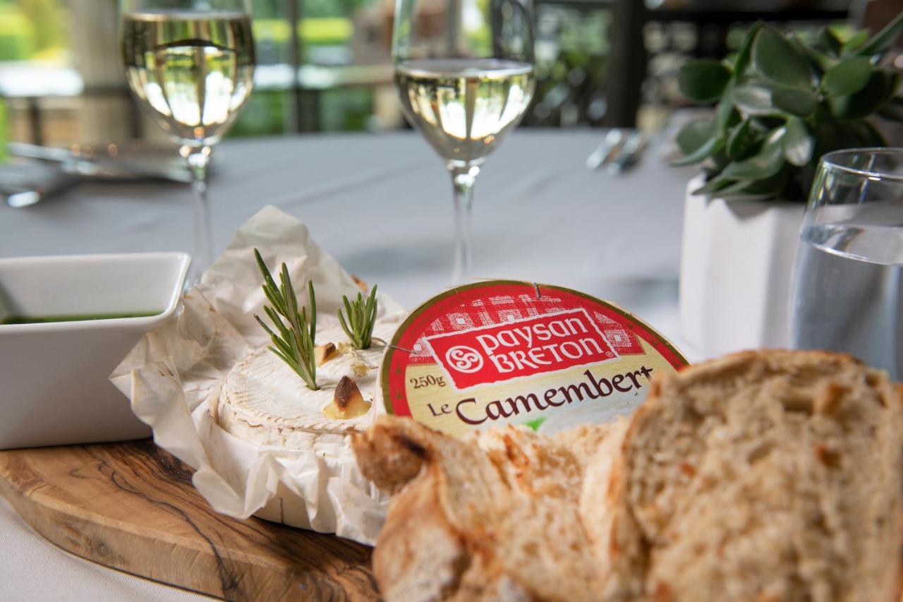 Macdonald Bath Spa Hotel Εξωτερικό φωτογραφία The photo features a dining setting that includes a wooden platter with a round Camembert cheese, garnished with fresh rosemary sprigs. Nearby, there is a serving of bread, likely sliced, and a small bowl, potentially for dipping or spreading. In the