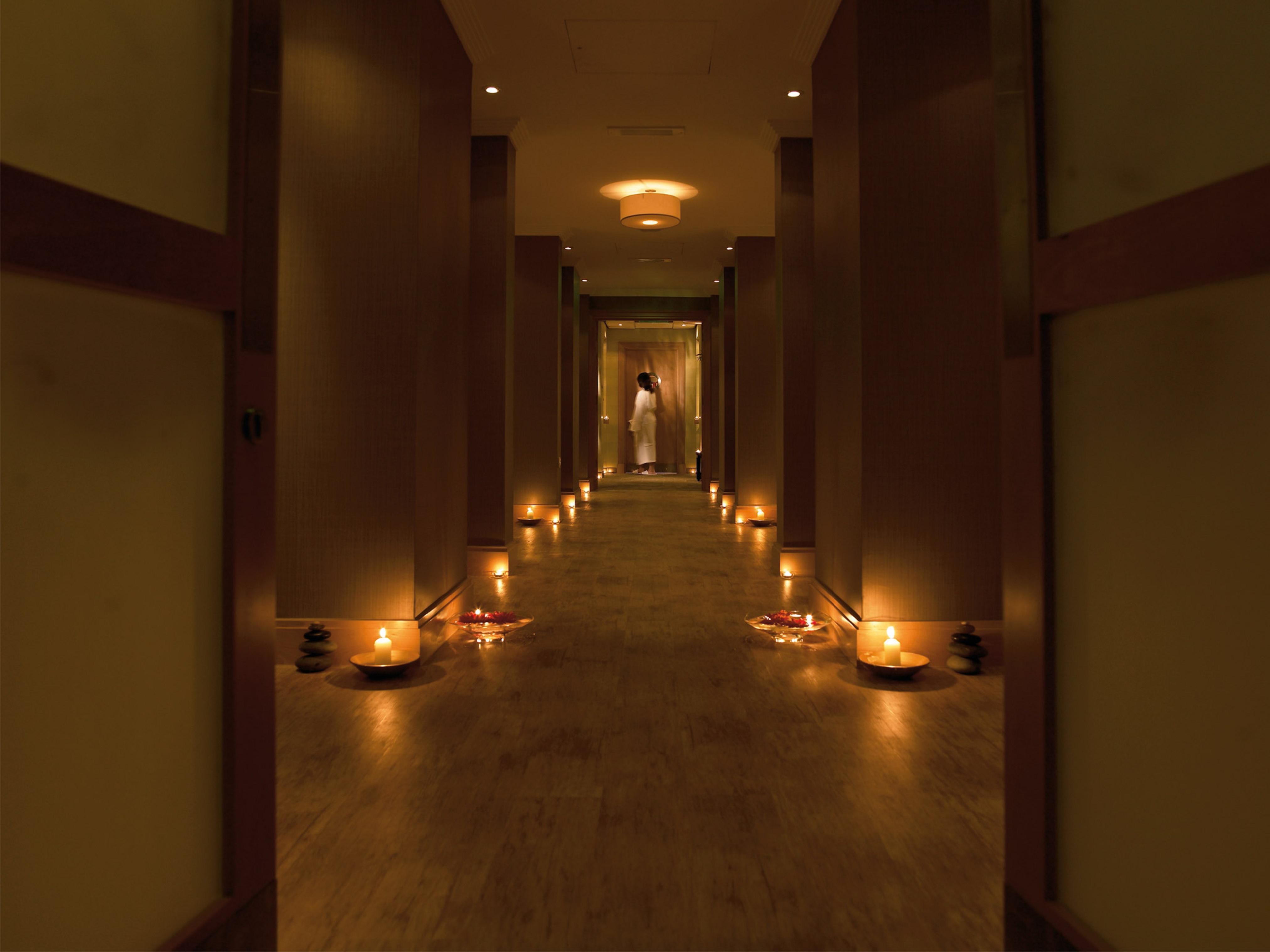Macdonald Bath Spa Hotel Εξωτερικό φωτογραφία The photo shows a dimly lit corridor lined with soft lighting. On both sides of the hallway, small candles are placed in bowls, creating a warm and inviting ambiance. At the end of the corridor, there appears to be a person standing, possibly prepari