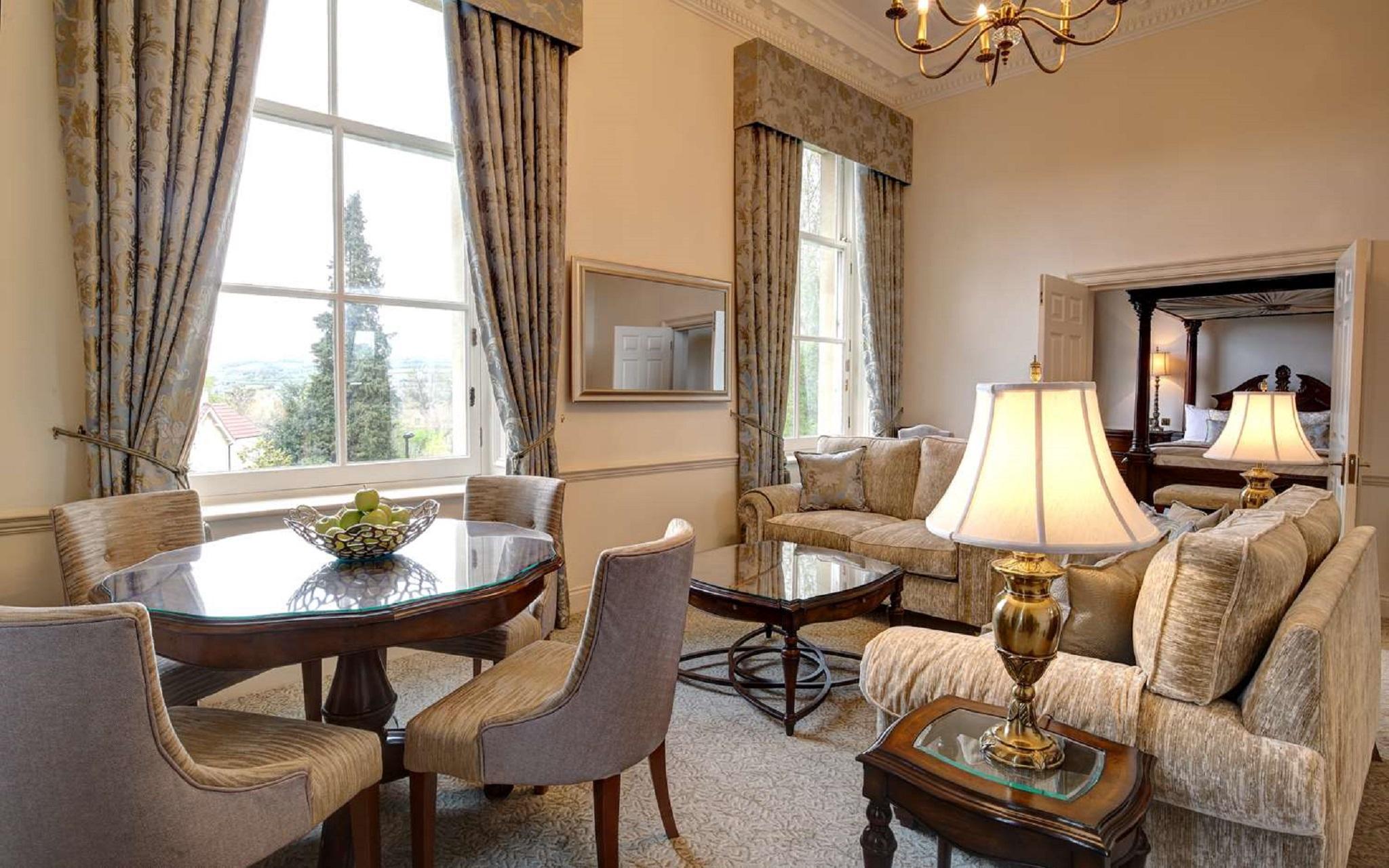 Macdonald Bath Spa Hotel Εξωτερικό φωτογραφία The photo displays a beautifully furnished living room. The room features large windows dressed with elegant curtains that allow natural light to flood in. There is a comfortable seating area with a stylish sofa and chairs arranged around a small cof