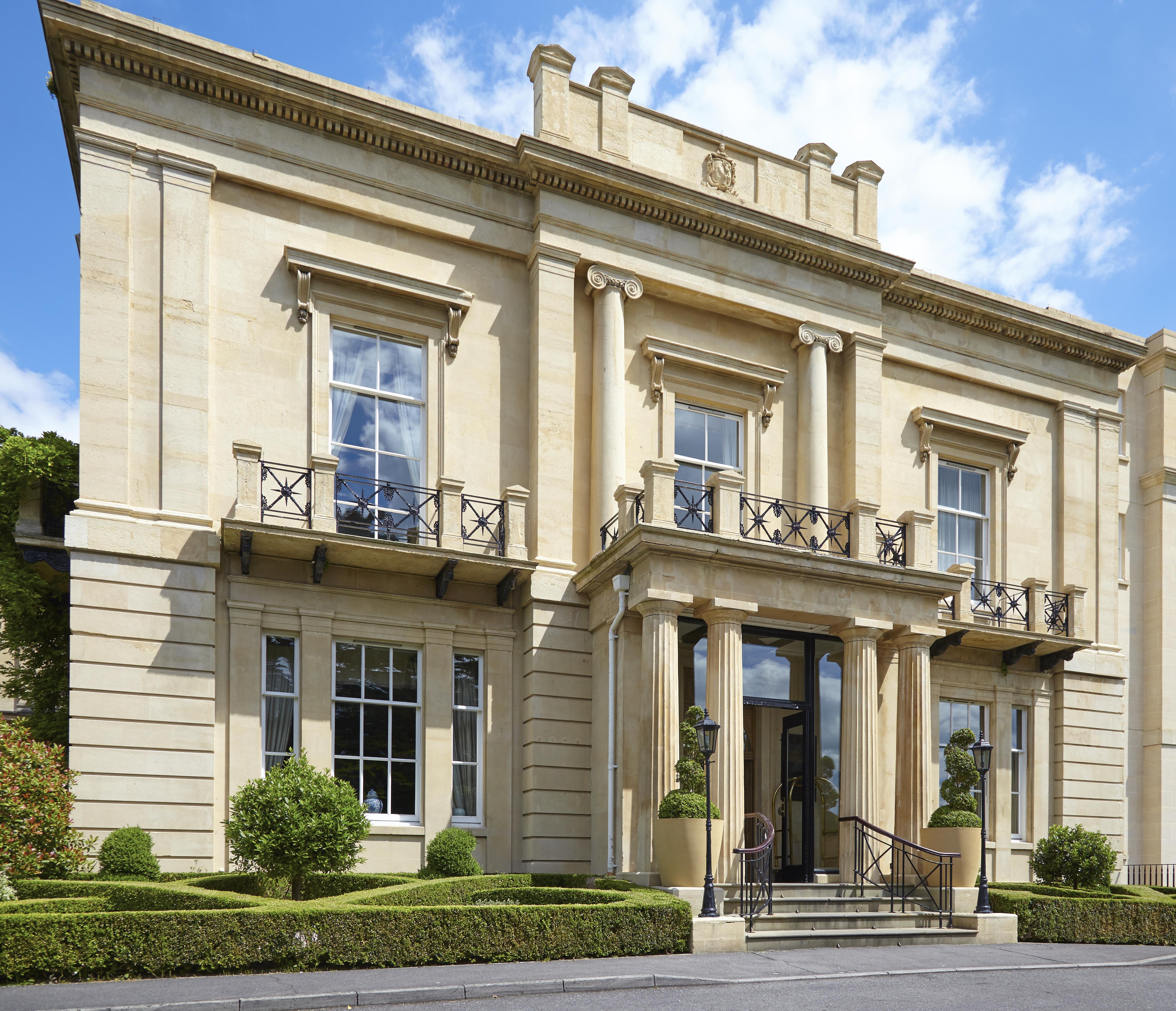 Macdonald Bath Spa Hotel Εξωτερικό φωτογραφία The photo shows a large, elegant building designed in a classical architectural style. It features a symmetrical facade with tall columns and decorative details. The entrance is marked by a set of stairs leading up to double doors, flanked by windows