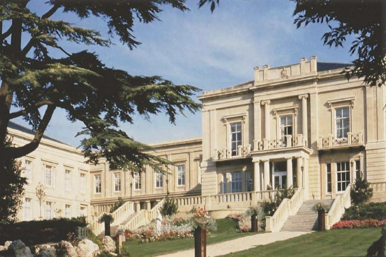 Macdonald Bath Spa Hotel Εξωτερικό φωτογραφία The photo depicts an elegant, stately building characterized by classical architecture. It features a symmetrical facade with large windows and decorative balconies. The structure is complemented by a lush green lawn and landscaped gardens, enhancing